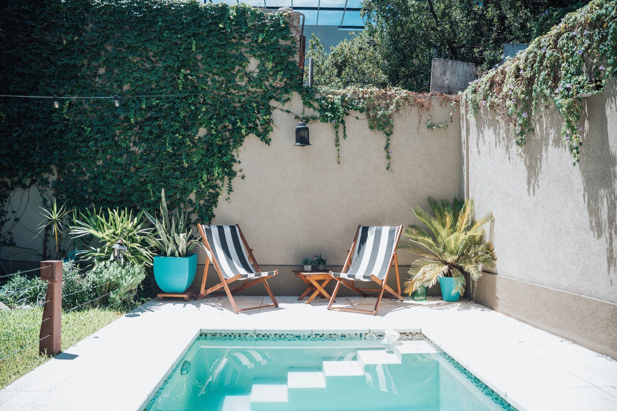 Outdoor deck seating area by a backyard pool